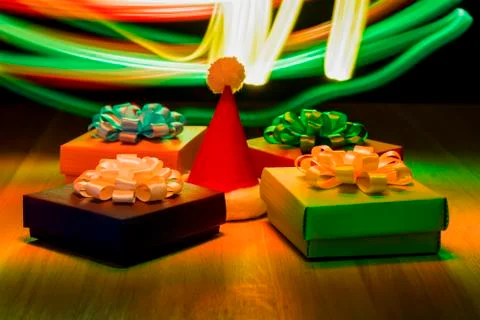 Multicolored boxes with bows. Christmas hat in the center. Yellow, blue and red 스톡 사진