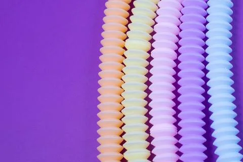 Multicolored bright tubes on blue background. Anti-stress sensory figet plastic Stock Photos