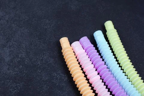 Multicolored bright tubes on blue background. Anti-stress sensory figet plastic Foto stock