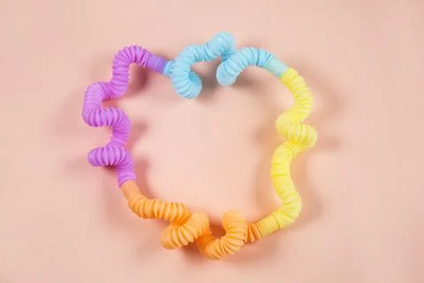 Multicolored bright tubes on light background. Anti-stress sensory figet plastic Foto stock