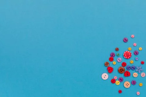 Multicolored buttons are scattered on the table. Top view with copy space, flat Stock Photos