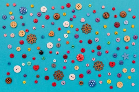 Multicolored buttons are scattered on the table. Top view with copy space, flat Stock Photos