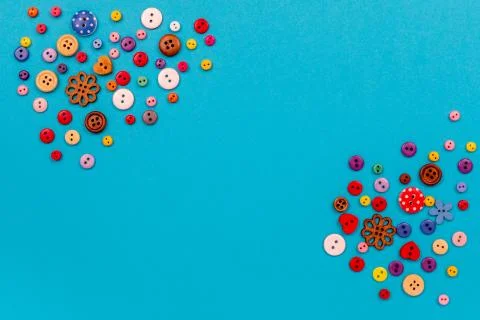 Multicolored buttons are scattered on the table. Top view with copy space, flat Stock Photos