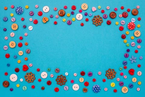 Multicolored buttons are scattered on the table. Top view with copy space, flat Stock Photos