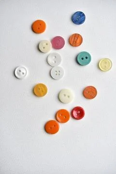 Multicolored buttons on a white background. Round buttons from clothes. Stockfoto's