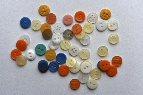 Multicolored buttons on a white background. Round buttons from clothes. Stockfoto's