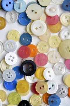 Multicolored buttons on a white background. Round buttons from clothes. Stockfoto's