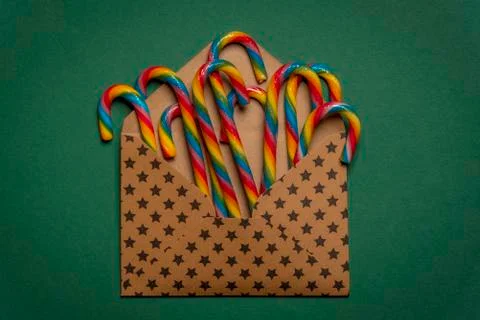 Multicolored candy canes in an open envelope Stock Photos
