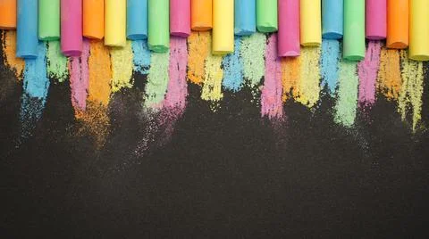 Multicolored chalk in row on black background. Education concept back to scho Stock Photos