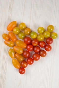 Multicolored cherry tomatoes with a shape of heart Stock Photos
