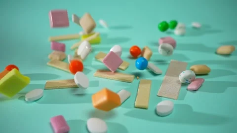 Multicolored chewing candies gum falling in slow mo on a blue background Stock Footage 223718503