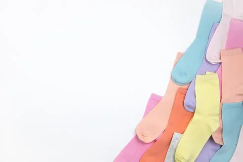 Multicolored children's socks without pattern, laid out in corner of frame, o Stock Photos