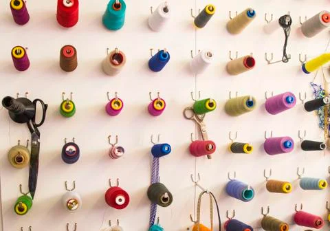 Multicolored coils and scissors on the wall Stock Photos