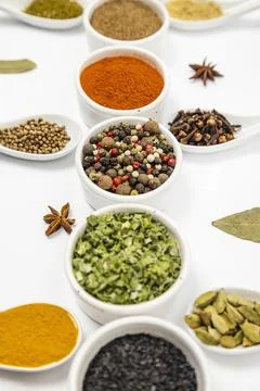 Multicolored condiments, different kinds of spices in ceramic bowls and spoons Stock Photos