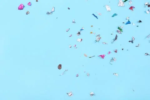 Multicolored confetti on blue background. Stock Photos