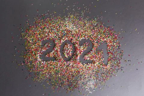 Multicolored confetti on a gray background 2021 year inscription. Stock Photos