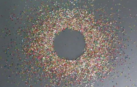 Multicolored confetti on a gray background circle inside Stock Photos