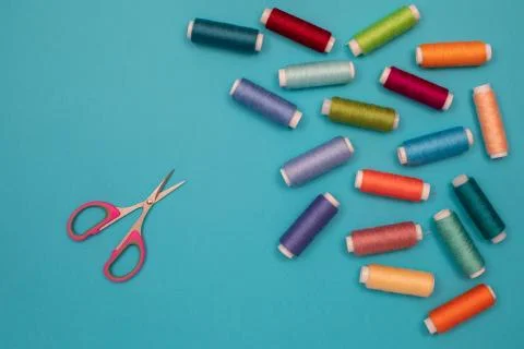 Multicolored cotton threads, spools, scissors, handmade sewing. Top view with Stock Photos