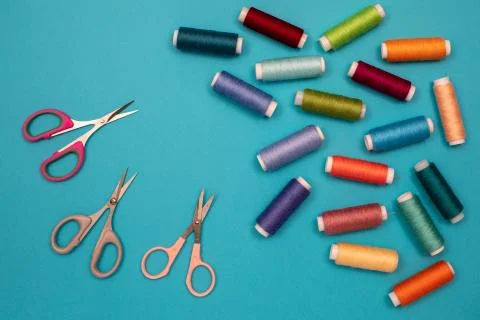 Multicolored cotton threads, spools, scissors, handmade sewing. Top view with Stock Photos