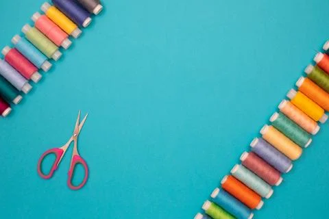 Multicolored cotton threads, spools, scissors, handmade sewing. Top view with Stock Photos