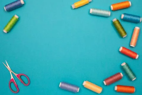 Multicolored cotton threads, spools, scissors, handmade sewing. Top view with Stock Photos