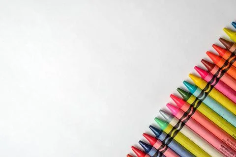 Multicolored crayons lined up on white background. Stock Photos