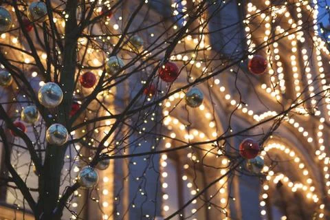 Multicolored decorations on trees and festive illumination on the streets of  Stock Photos