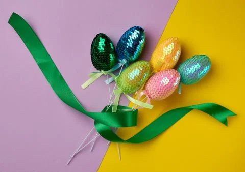 Multicolored decorative Easter eggs decorated with sequins on a color backgro 스톡 사진