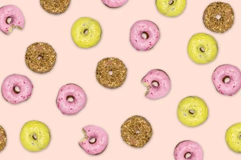 Multicolored donuts with icing on pink background. Top view, flat lay. Stock Photos