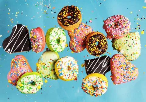 Multicolored donuts isolated on blue background. Top view. Stock Photos