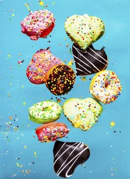 Multicolored donuts isolated on blue background. Top view. Stock Photos