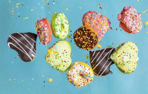 Multicolored donuts isolated on blue background. Top view. Stock Photos