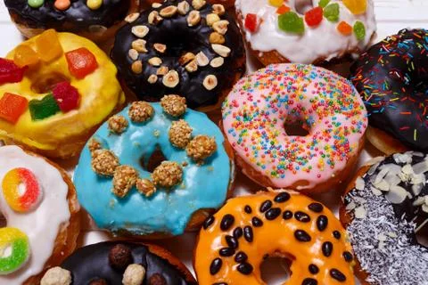 Multicolored donuts isolated on white background. Top view Stock Photos