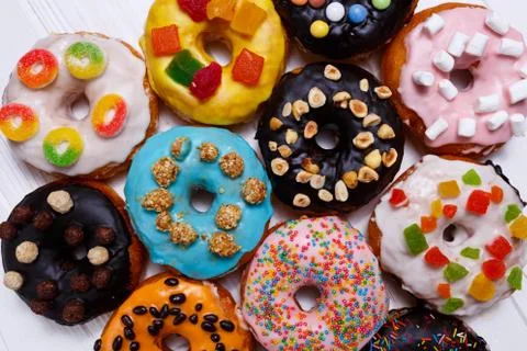 Multicolored donuts isolated on white background. Top view Stock Photos