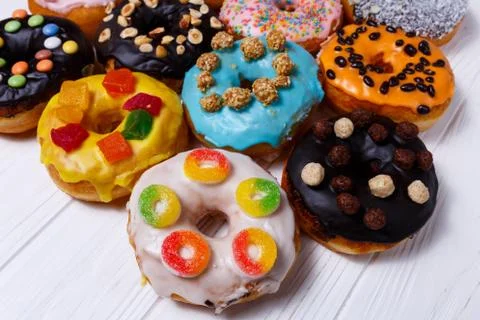 Multicolored donuts isolated on white background. Top view Stock Photos