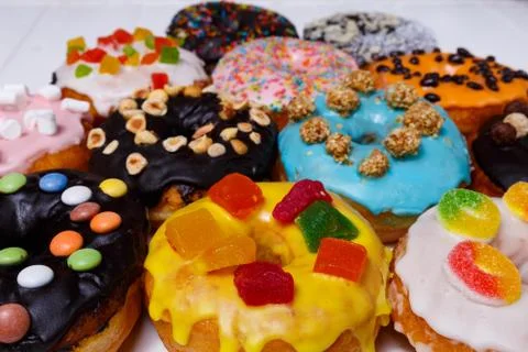 Multicolored donuts isolated on white background. Top view Stock Photos