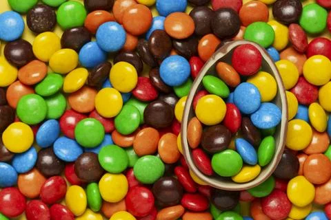 Multicolored dragee with Easter chocolate egg 写真素材