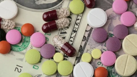 Multicolored drugs on a background of dollars Stock Footage 125844690