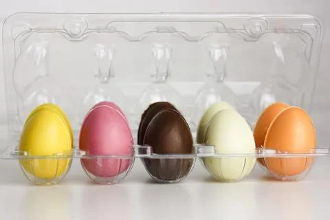 Multicolored Easter chocolate eggs in thermoplastic egg packaging on a white Stock Photos