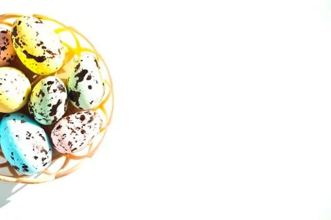 Multicolored Easter eggs lie in a round basket. the view from the top. The Stock Photos