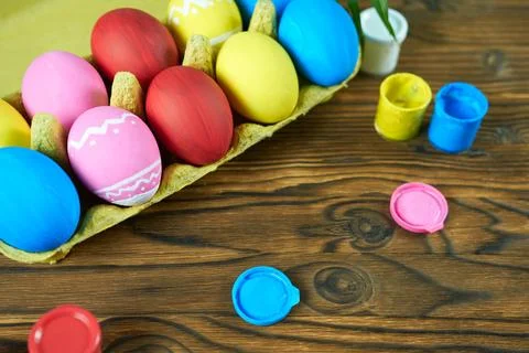 Multicolored Easter eggs in a package on a wooden background. Stock Photos