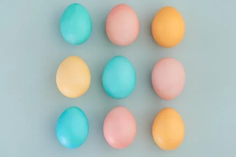 Multicolored easter eggs painted in pastel colors on a blue background Stock Photos