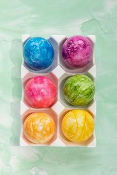 Multicolored Easter eggs in porcelain storage organizer box on green background Stock Photos