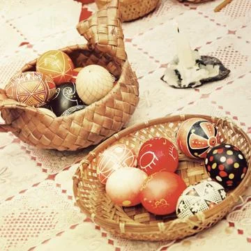 Multicolored easter eggs in straw pots. Stock-Fotos