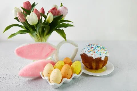 Multicolored Easter eggs on a tray on a table set for Easter. Fotos Stock
