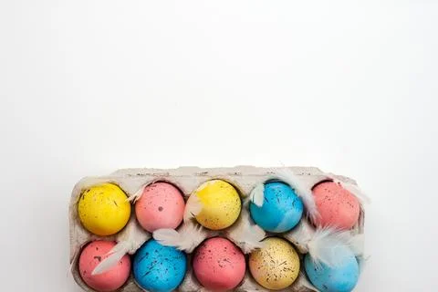 Multicolored Easter eggs on a white background. Top view, copy space. Stock Photos