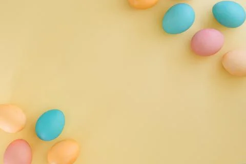 Multicolored easter eggs on yellow background with space for text, top view Stock Photos