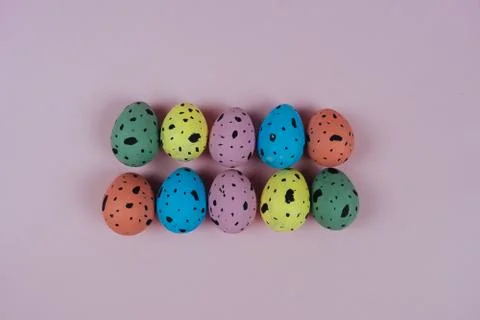 Multicolored Easter quail eggs isolated on pink background. Happy Easter and Stock Photos