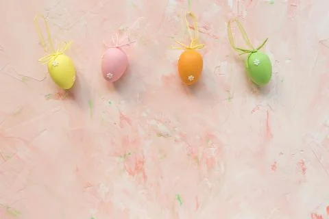 Multicolored eggs decoration on a pink background. Easter celebration concept Stock Photos