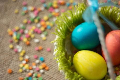Multicolored eggs in easter festive basket on canvas napkin. 写真素材